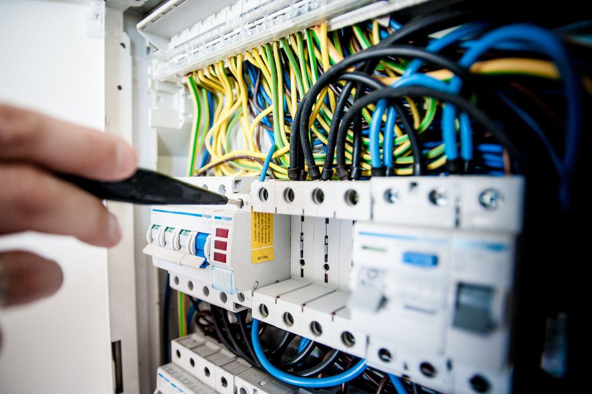 Hand working on a circuit breaker panel